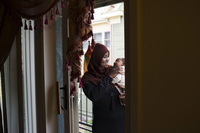 Hamdi holds Nimcaan on the balcony of her home in Minneapolis.