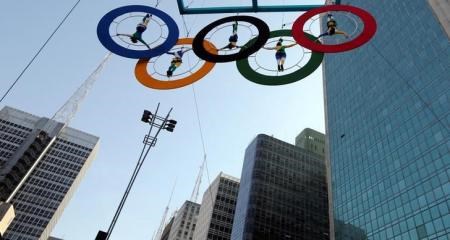 Acrobats perform on the Olympics rings at Paulista Avenue in Sao Paulo"s financial center, Brazil, July 24, 2016.