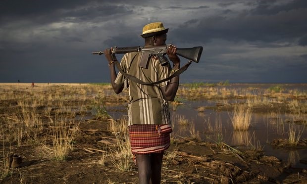 An armed Turkana man on the shore of Lake Turkana. Locals fear the completion of the Gibe III dam could exacerbate tension in the region between Kenyans and Ethiopians. Photograph: Siegfried Modola/Reuters