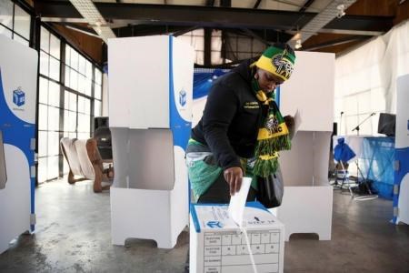 A women wearing ANC regalia casts her vote during the local government elections in Hillbrow, central Johannesburg, South Africa August 3,2016.