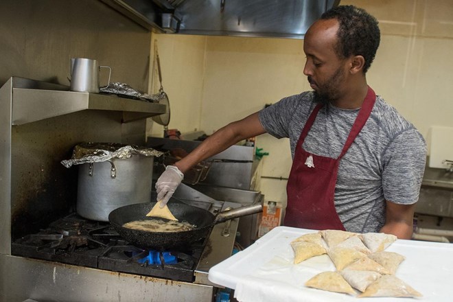 Ahmed Musse puts sambusa into a frying pan in the kitchen at Brothers Restaurant and Grocery. Sambusa is an African pastry filled with ground meat or vegetables. Photo by Jackson Forderer